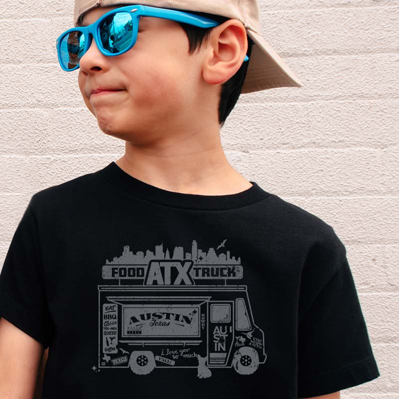 Model wearing our ATX Food Truck youth t-shirt with fun food truck graphic – playful Austin street food tee for kids