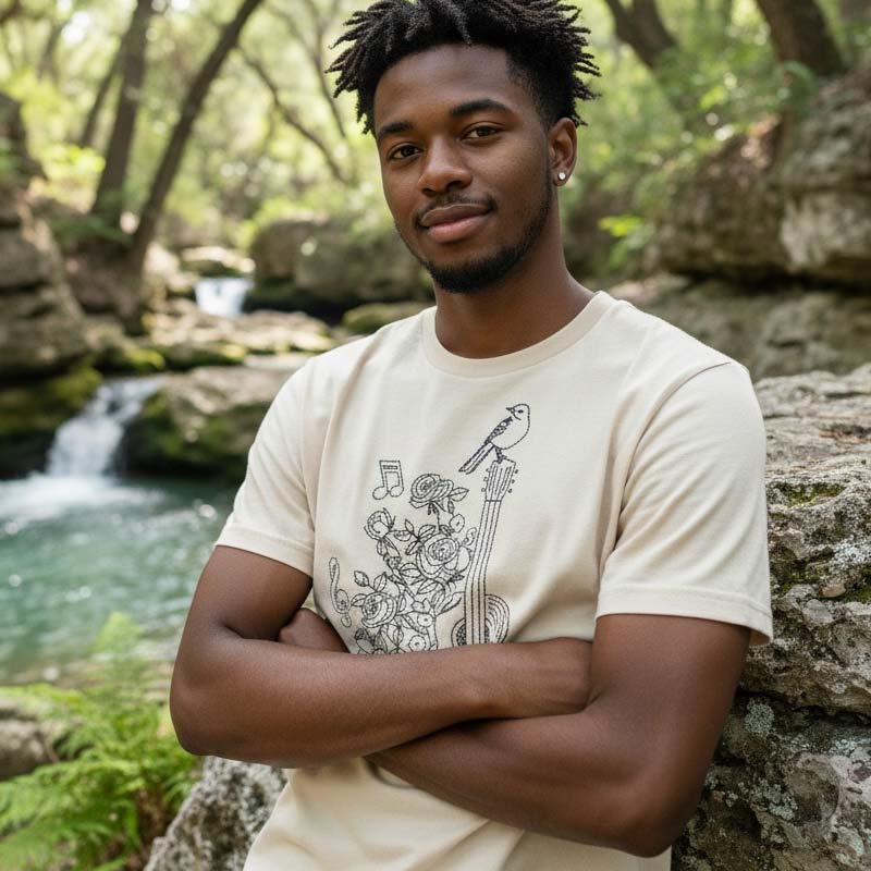 Man wearing a white t-shirt with a graphic design in a natural setting