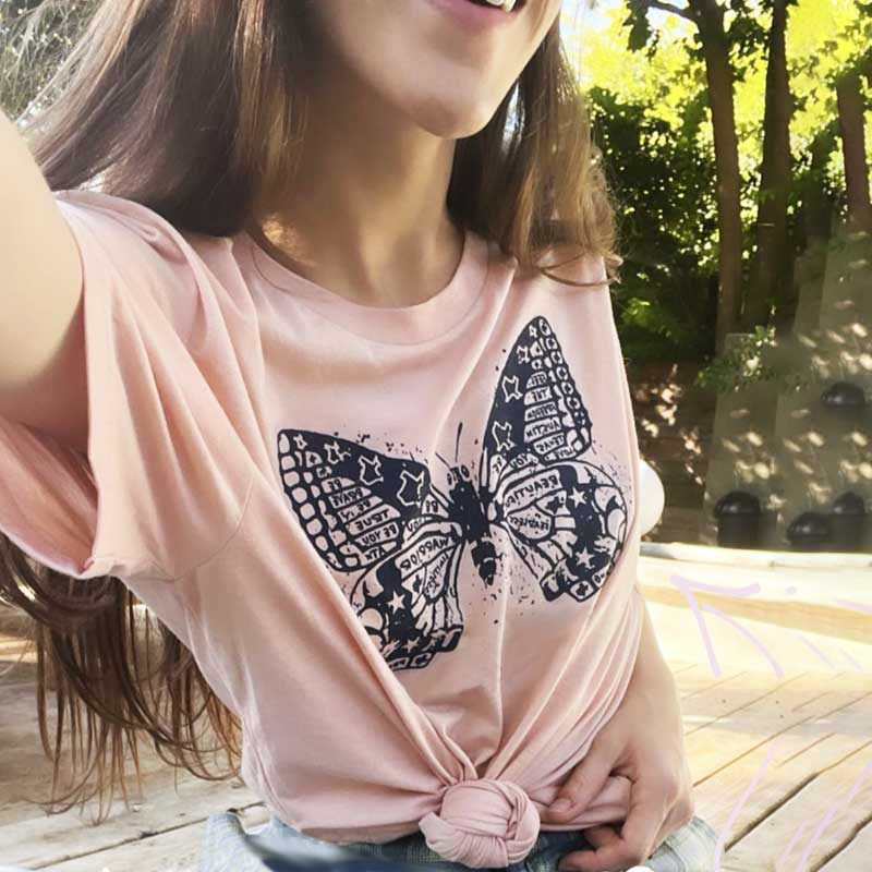 Model wearing Butterfly ATX t-shirt outdoors, showcasing nature-inspired Austin design