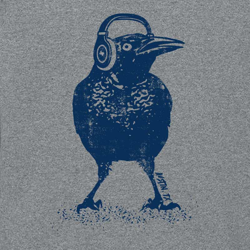 Grey crewneck sweatshirt featuring a bold graphic of a grackle bird wearing headphones, with the words 'Austin TX' in a fun, modern font. A playful nod to Austin's music scene and iconic city bird.
