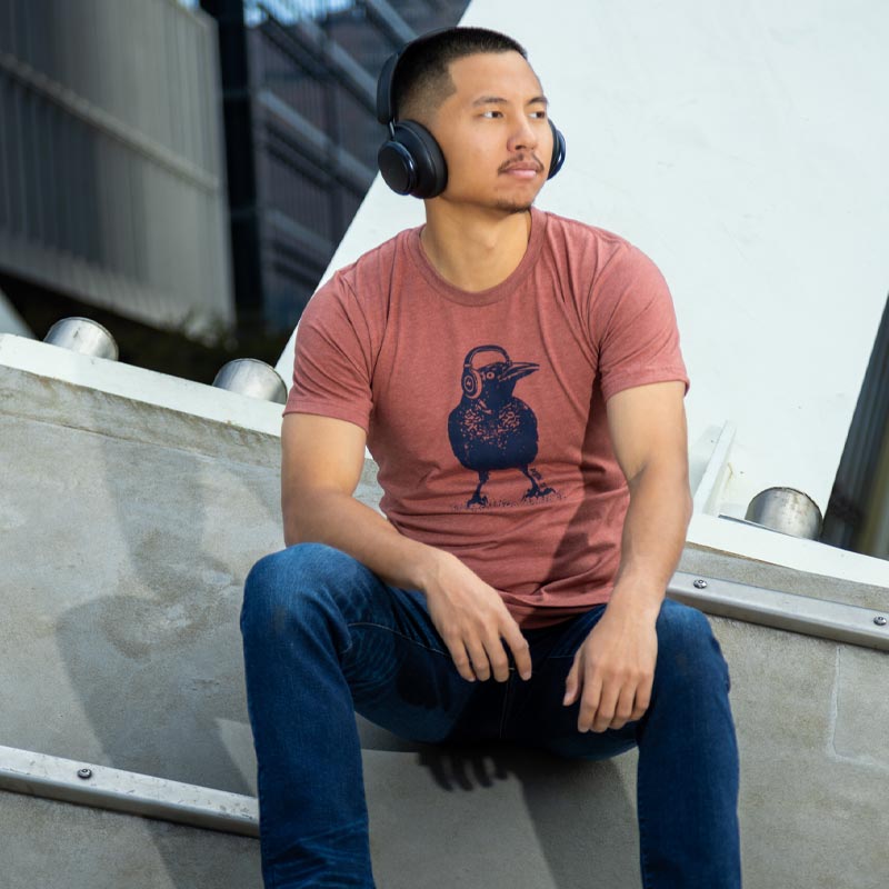 Model wearing Beats Austin Grackle t-shirt, showcasing playful bird and music design