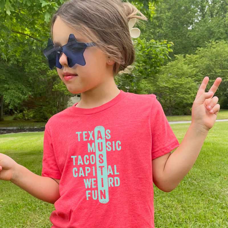 Model wearing our Crossword ATX youth t-shirt with playful puzzle-style graphic – fun and clever Austin-themed tee for kids