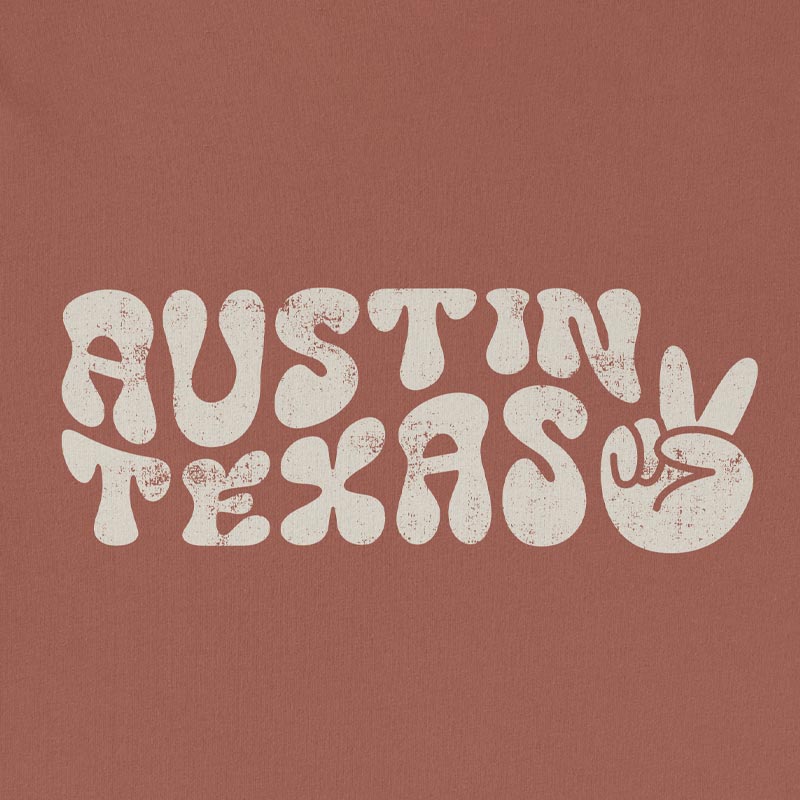 Close-up of funky, colorful Austin text and peace sign graphic printed on t-shirt