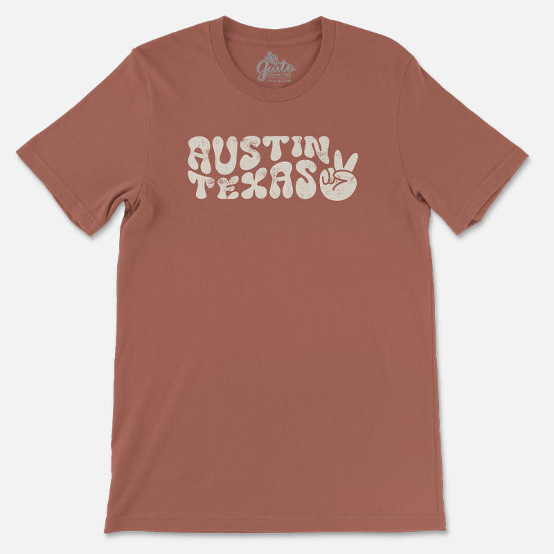 T-shirt featuring retro wavy “Austin” text with peace sign design on soft cotton fabric