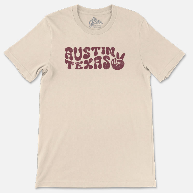 T-shirt featuring retro wavy “Austin” text with peace sign design on soft cotton fabric