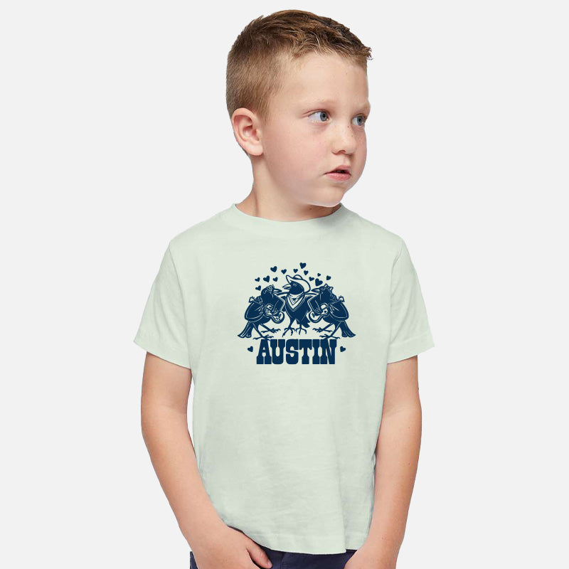 Child wearing a light green t-shirt with a blue graphic and 'Austin' text on a white background