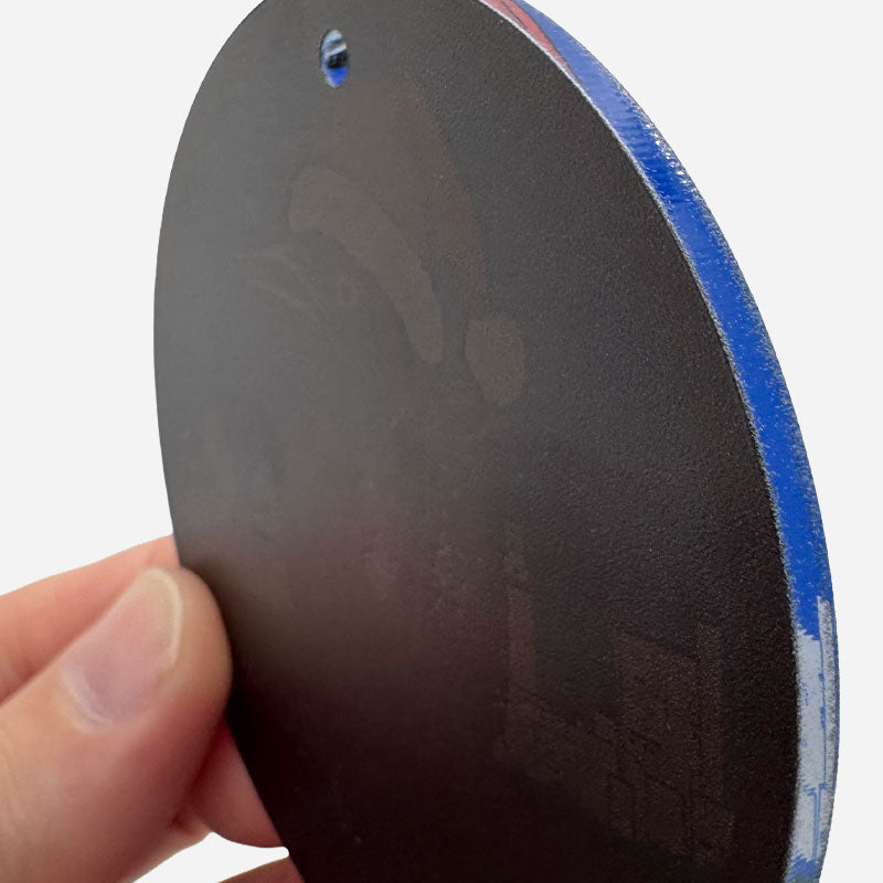 Close-up of a black and blue object held by a hand on a white background