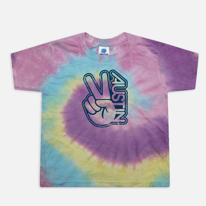 Flat lay of the Groovy Austin Toddler Tee in Jellybean tie-dye, showcasing the vibrant rainbow colors and retro Austin graphic.