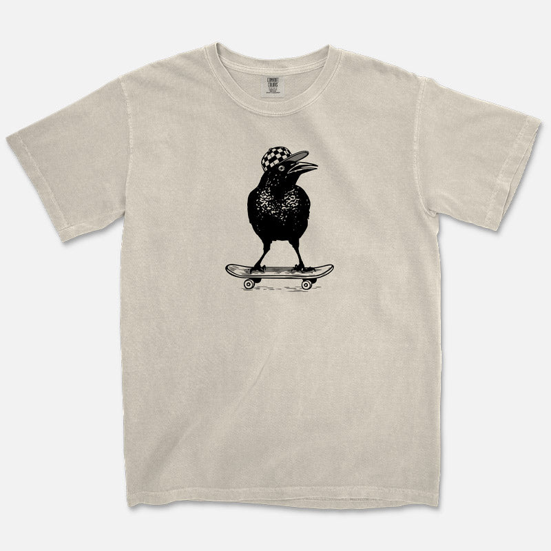Ivory Comfort Colors 1717 t-shirt with a black graphic of a grackle bird on a skateboard on a white background