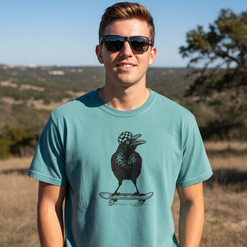 Man wearing a teal t-shirt with a graphic design outdoors
