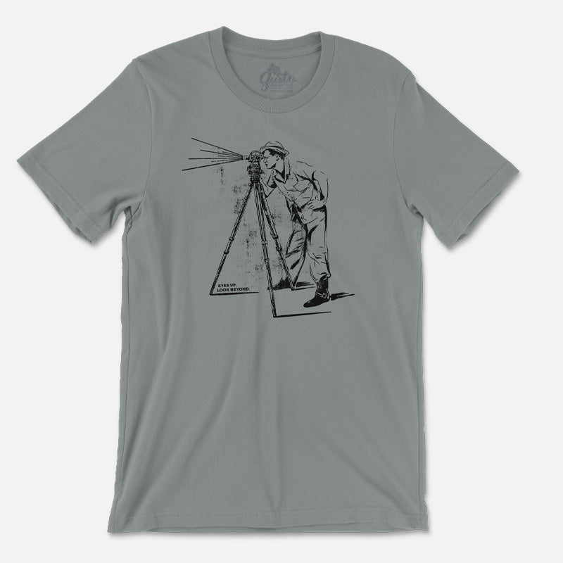 Retro-style t-shirt with vintage photo of man using telescope and text "Eyes Up, Look Beyond"