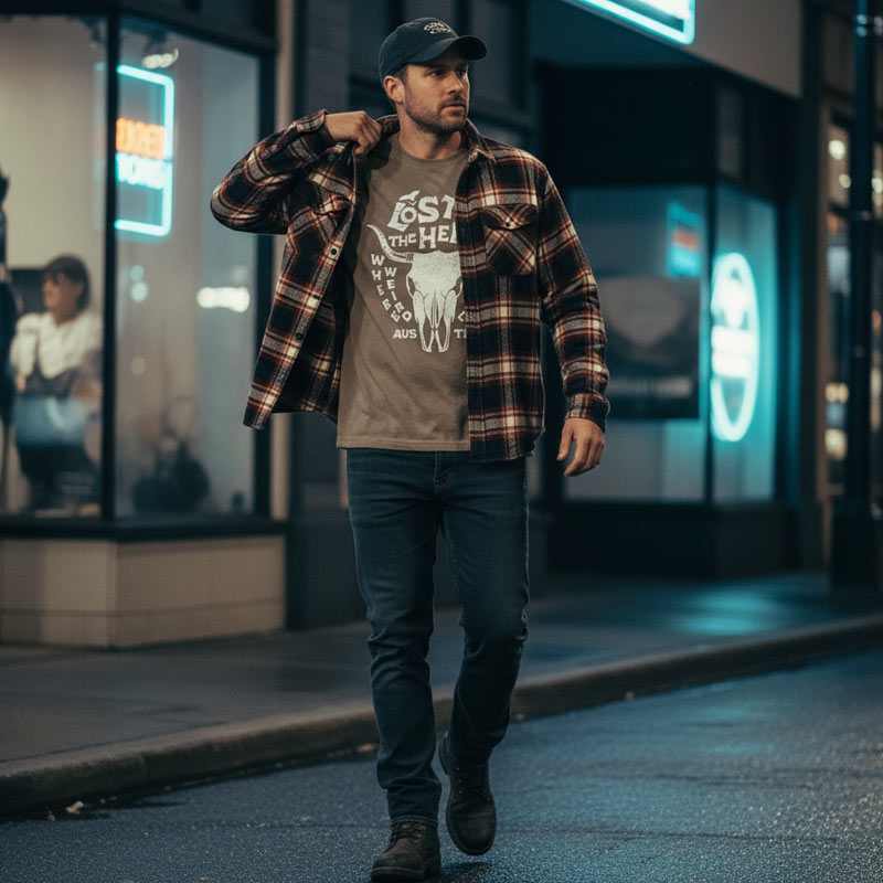 Man walking on a city street at night with neon signs in the background