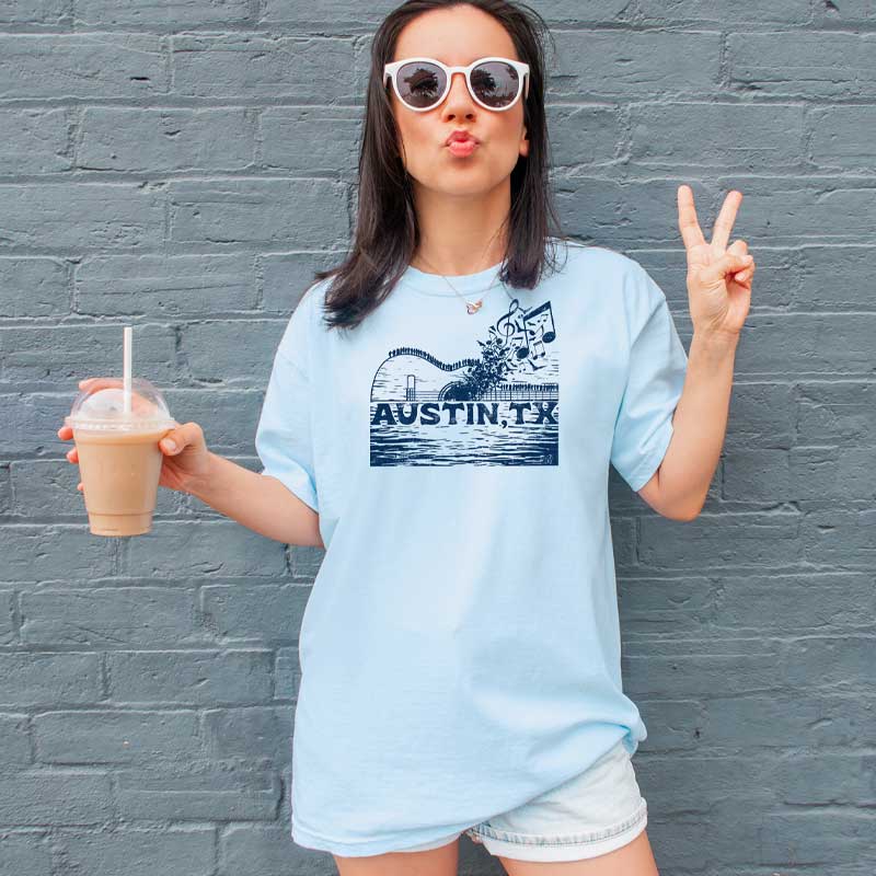 Model wearing ATX Music Bridge T-shirt, blending city skyline and live music theme