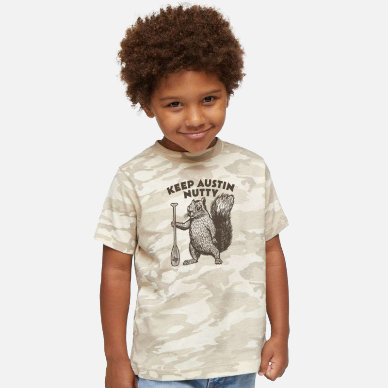 Child wearing a camouflage t-shirt with a graphic design and text on a white background