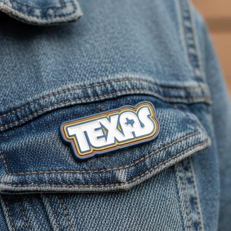 Blue denim jacket with a 'Texas' patch on the chest.