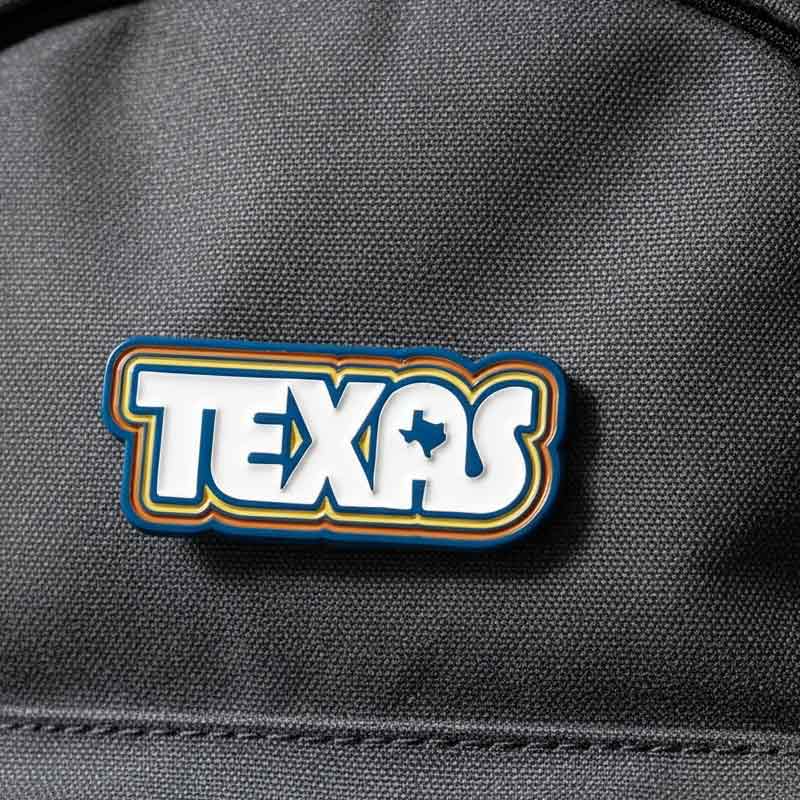 Texas-shaped patch on a dark fabric background