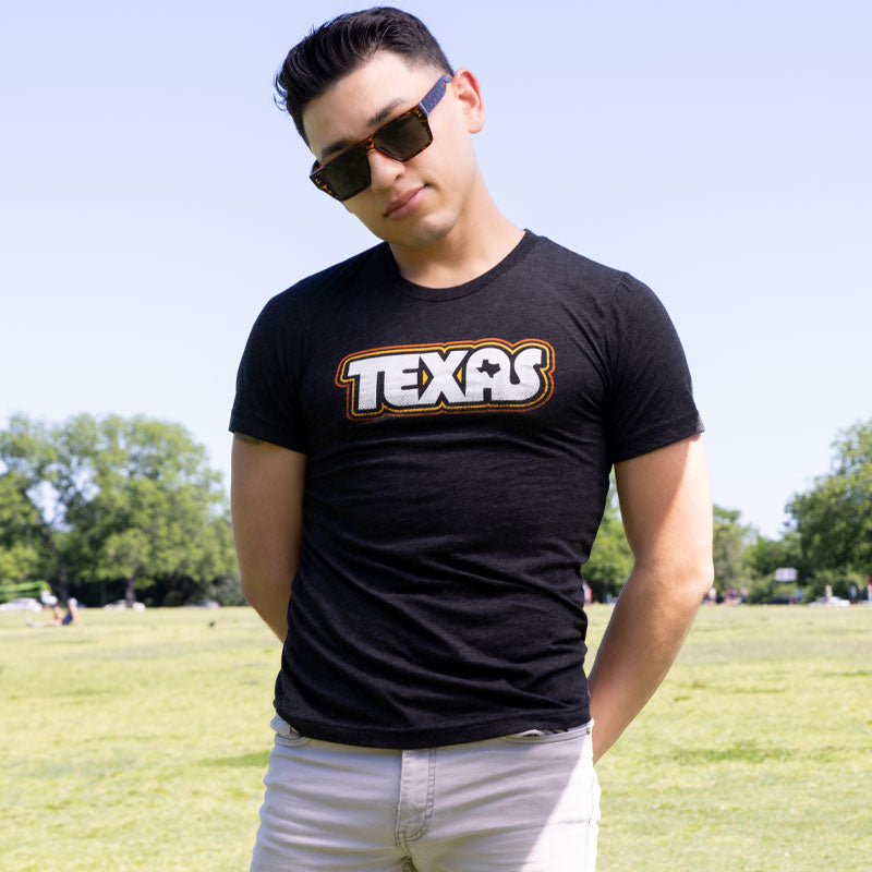 Model wearing Retro Texas T-shirt with bold vintage typography, standing outdoors in natural light