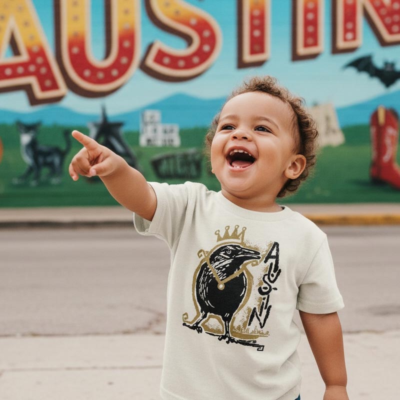 Child pointing towards a colorful mural with large letters and cartoon characters.
