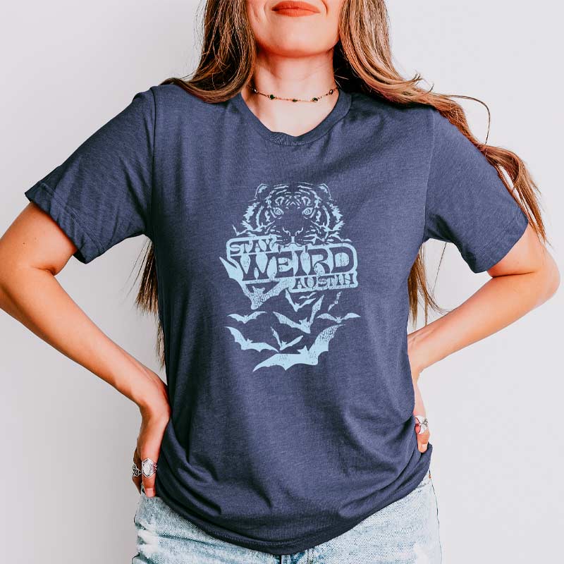 Model wearing Stay Weird Austin t-shirt with bold lettering, celebrating local Austin culture