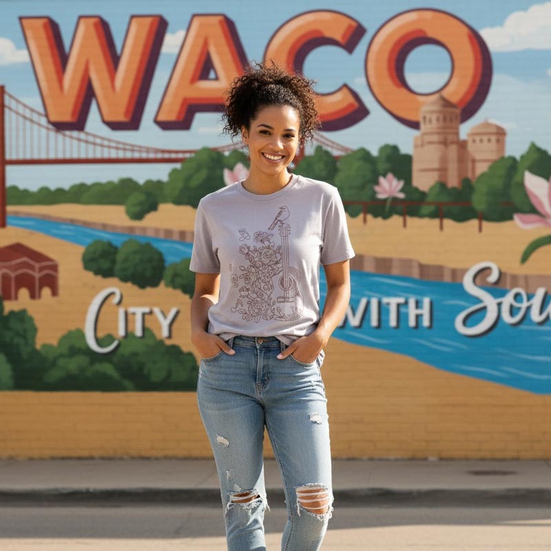 Woman standing in front of a colorful mural with 'Waco' and a scenic depiction.