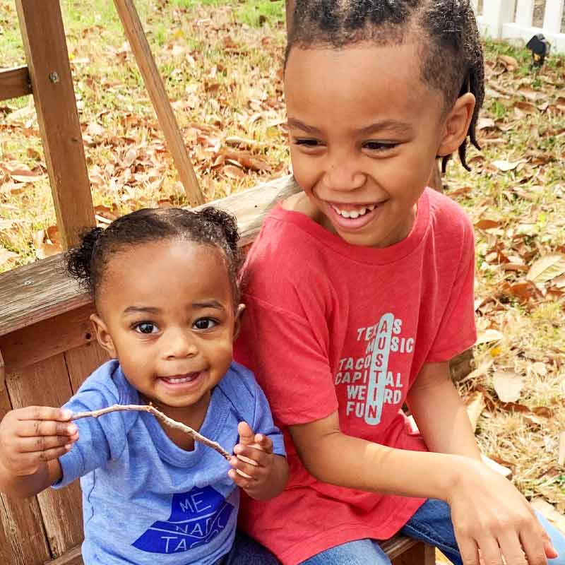 Model wearing our Crossword ATX youth t-shirt with playful puzzle-style graphic – fun and clever Austin-themed tee for kids