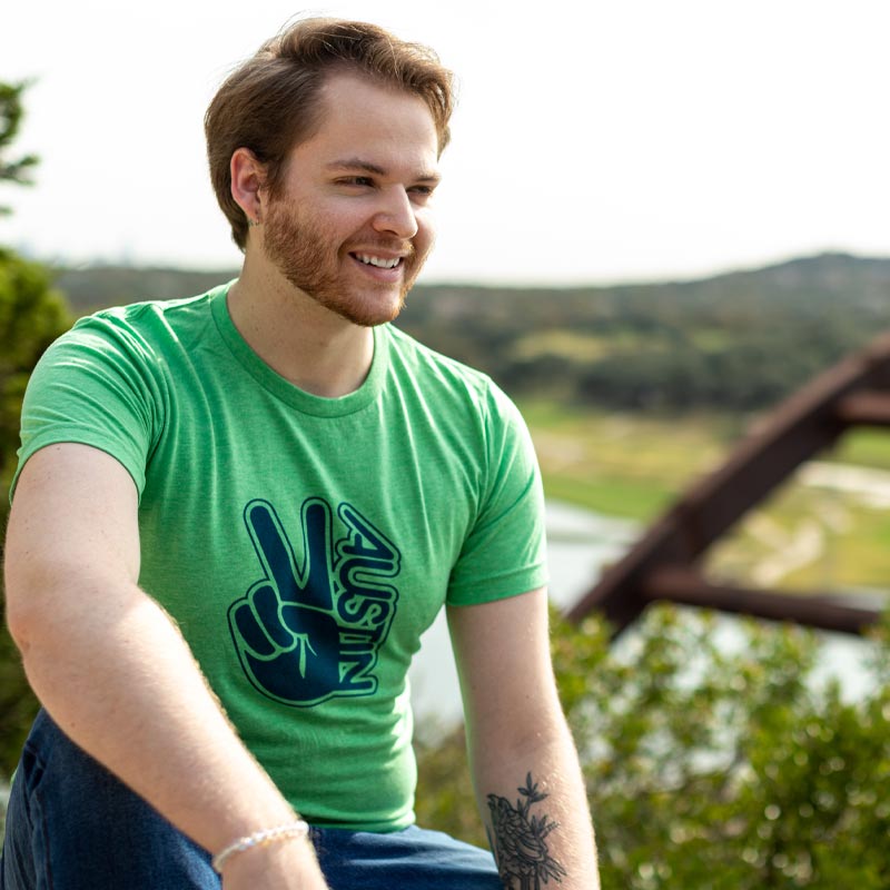 Model wearing Groovy Austin Peace T-shirt with 70s-style design and bold lettering