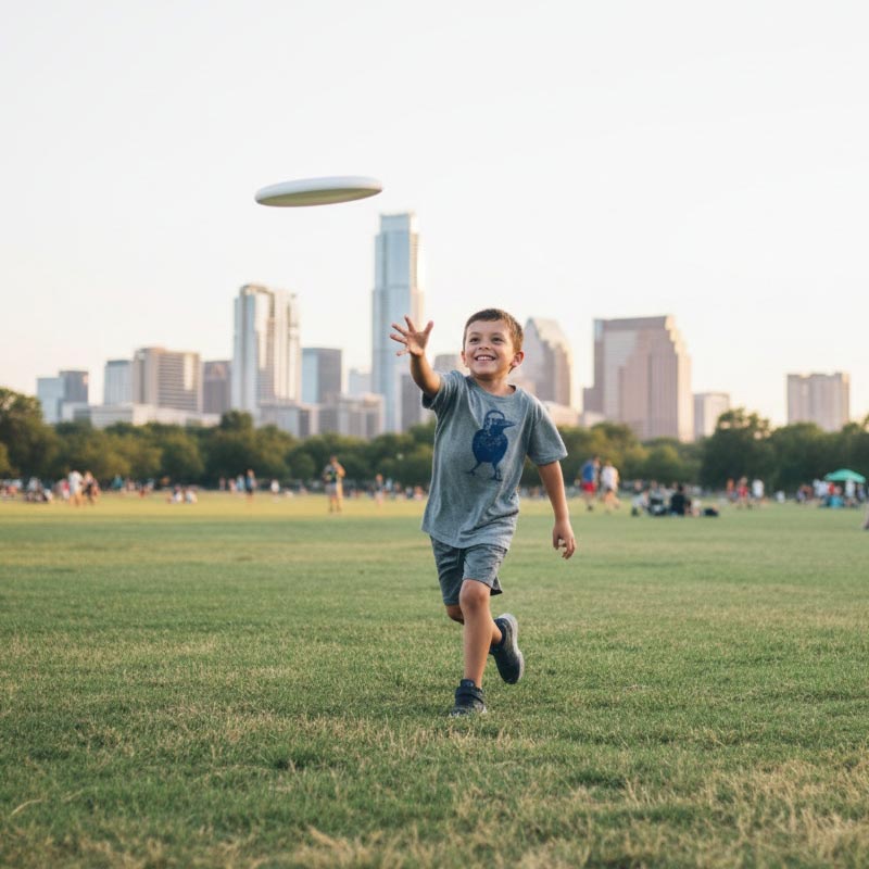 Child playing with a frisbee in a park with city skyline in the background