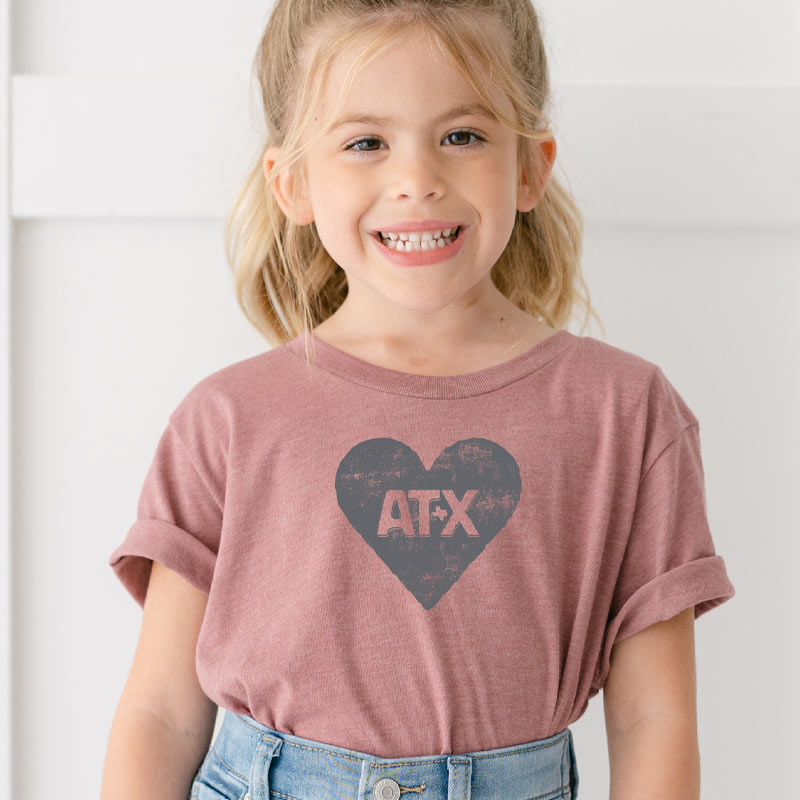 Model wearing our ATX Heart youth t-shirt with bold heart graphic – fun and proud Austin-themed tee for kids