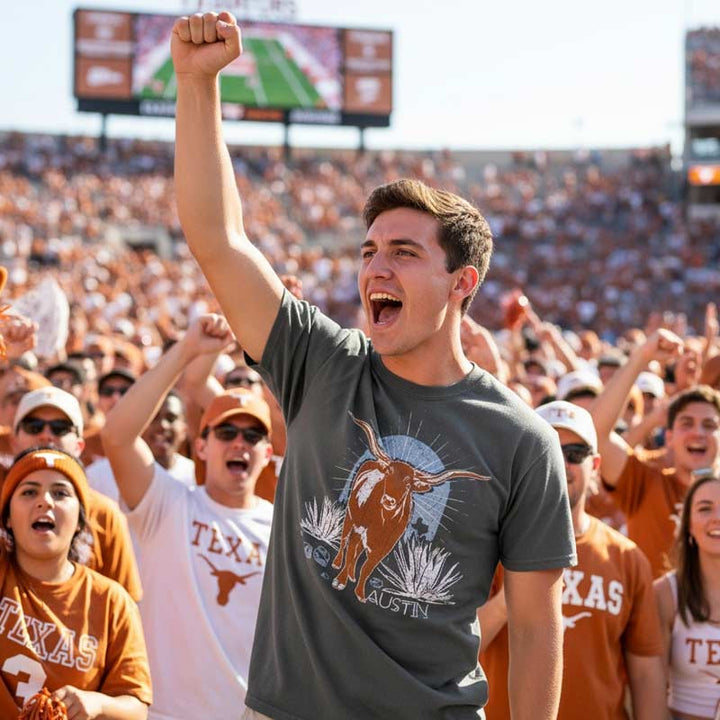Person cheering at a sports event with 'Texas' branding