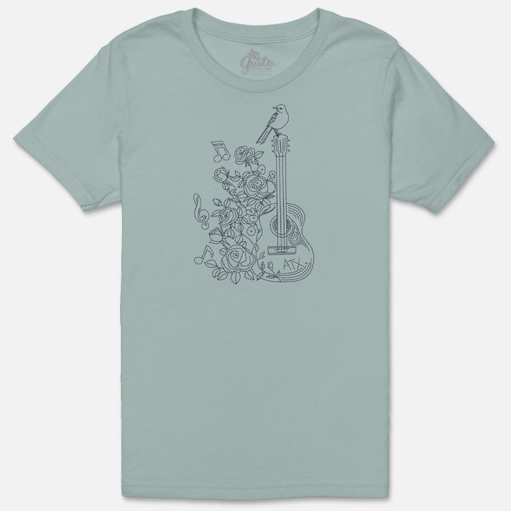 Flat lay of the Songbird & Strings tee showing the detailed bird and guitar design on soft garment-dyed cotton.