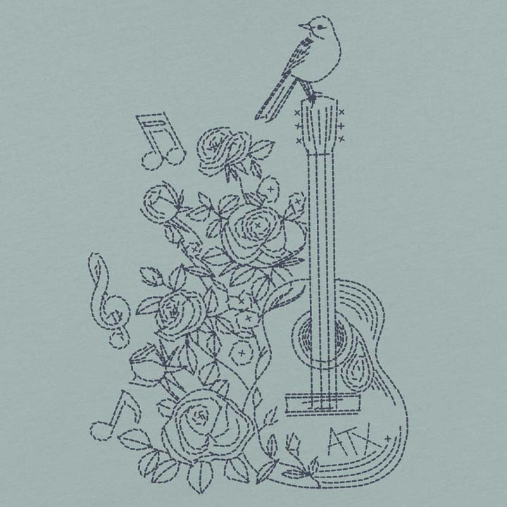 Embroidered design of a guitar, roses, and musical notes on a light blue background