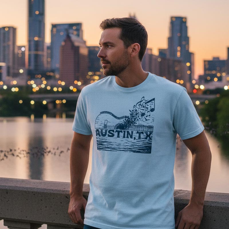 Man wearing a light blue t-shirt with 'Austin, TX' design against a cityscape background.