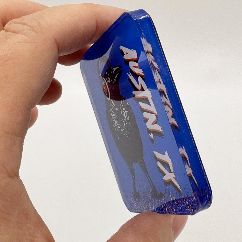 Acrylic magnet featuring a cartoon grackle wearing headphones, inspired by Austin, Texas culture.