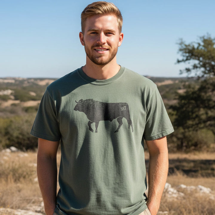 Man wearing a green t-shirt with a bull graphic outdoors
