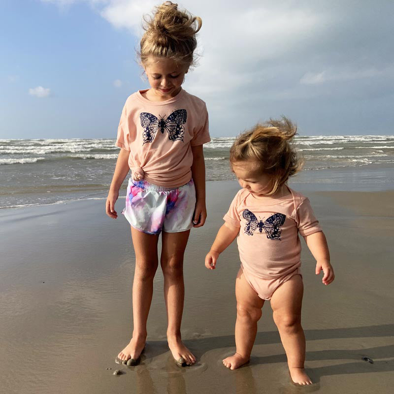 Model wearing our Butterfly ATX youth t-shirt with vibrant butterfly graphic – fun and whimsical Austin-themed tee for kids