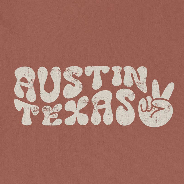 Close-up of funky, colorful Austin text and peace sign graphic printed on t-shirt