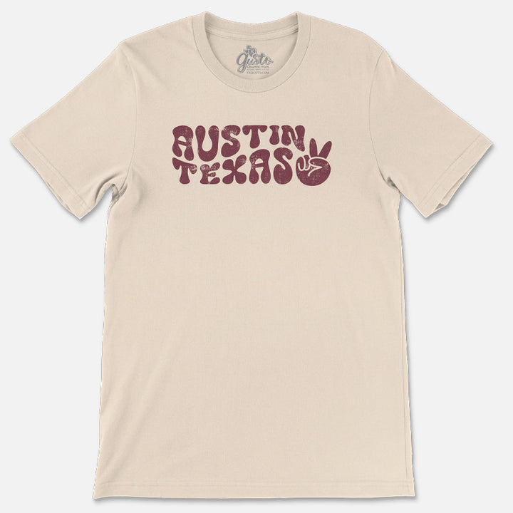 T-shirt featuring retro wavy “Austin” text with peace sign design on soft cotton fabric