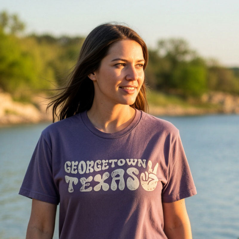 Lifestyle photo of person wearing Wine Georgetown Groove tee at Lake Georgetown in spring
