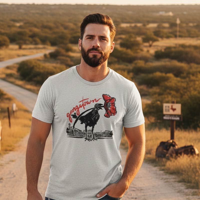 Man wearing a Georgetown Grackle T-shirt in a scenic outdoor setting.