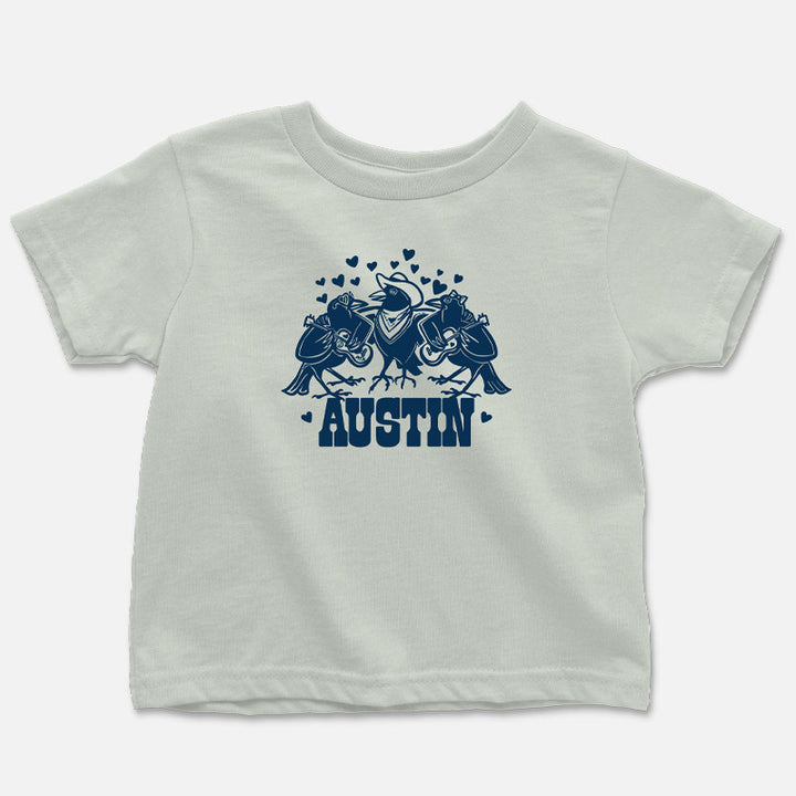 Three cartoon grackles playing musical instruments on a toddler-sized t-shirt — fun, music-themed design printed on soft cotton.