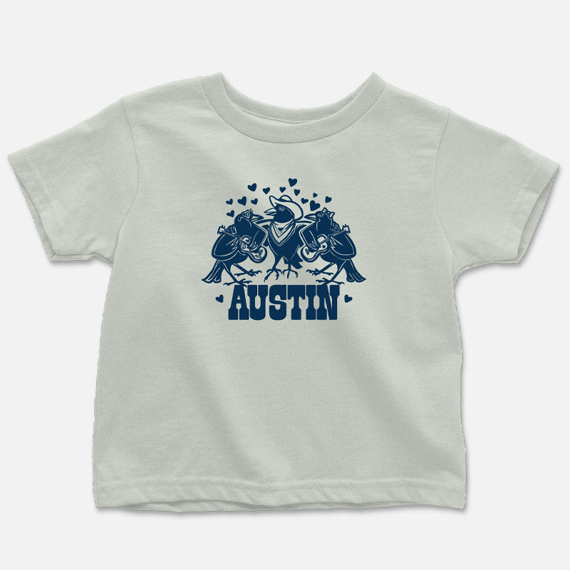 Three cartoon grackles playing musical instruments on a toddler-sized t-shirt — fun, music-themed design printed on soft cotton.
