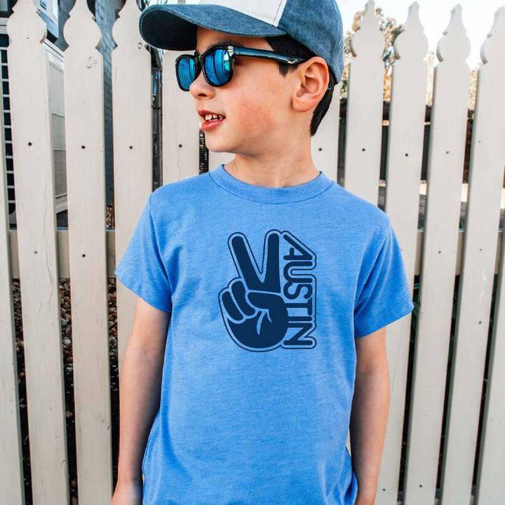 Model wearing our Groovy Austin youth t-shirt with retro-inspired graphic – colorful and fun ATX tee for kids