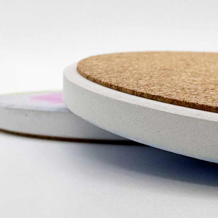 Close-up of a cork coaster with a white base on a light gray background