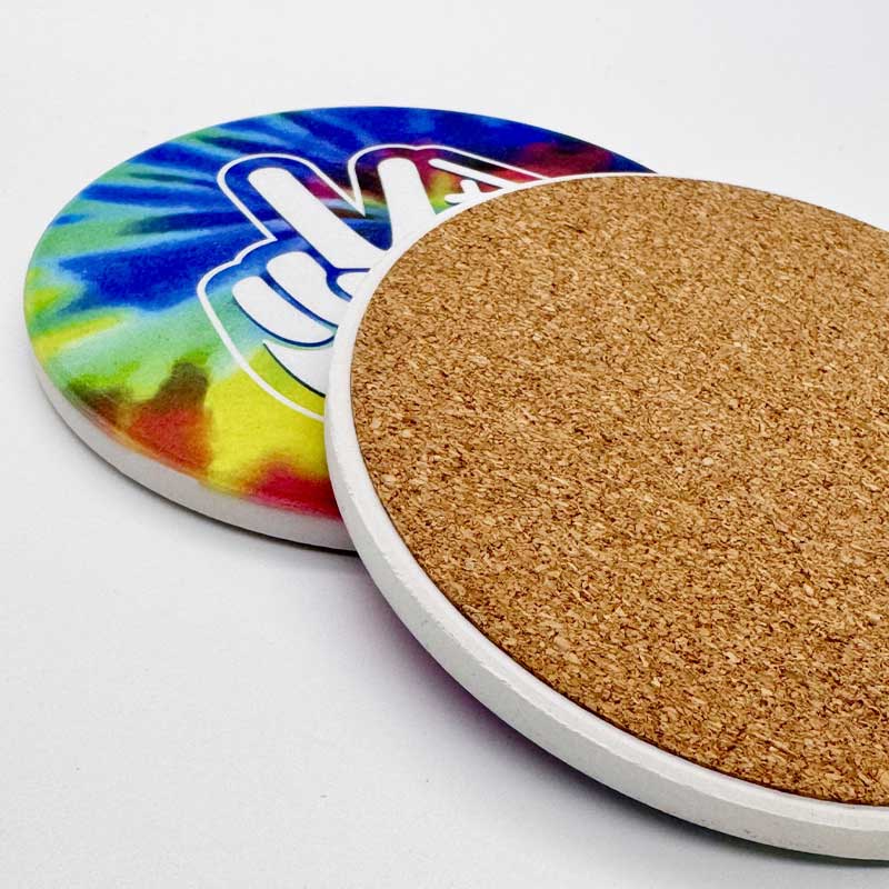 Two coasters, one with a tie-dye design and the other with a cork back, on a white background.