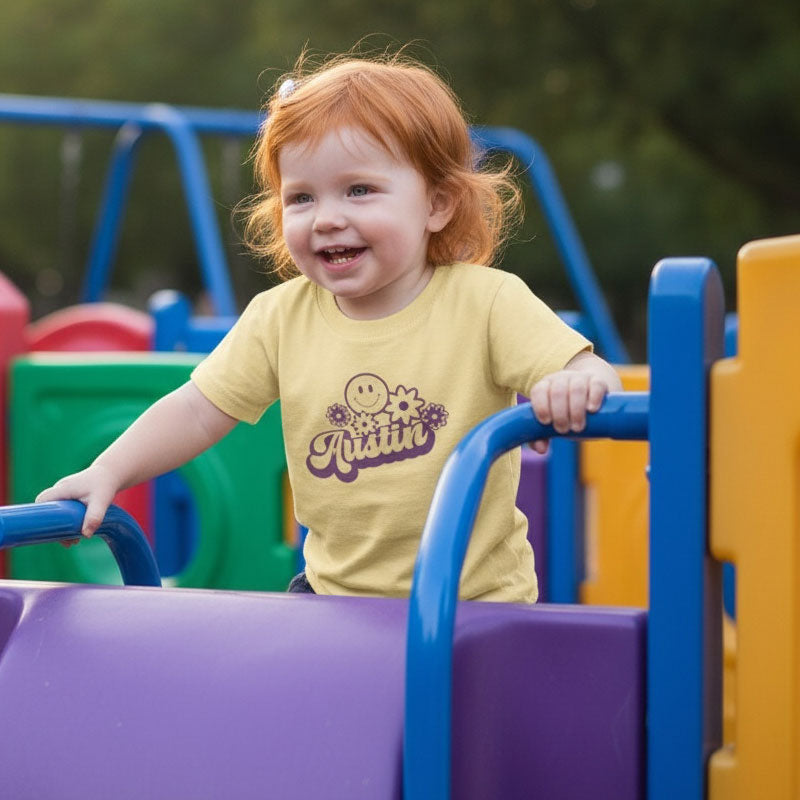 Child playing on a colorful playground structure with a yellow shirt.