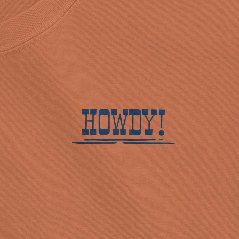 burnt orange t-shirt with 'HOWDY!' text in blue on a plain background