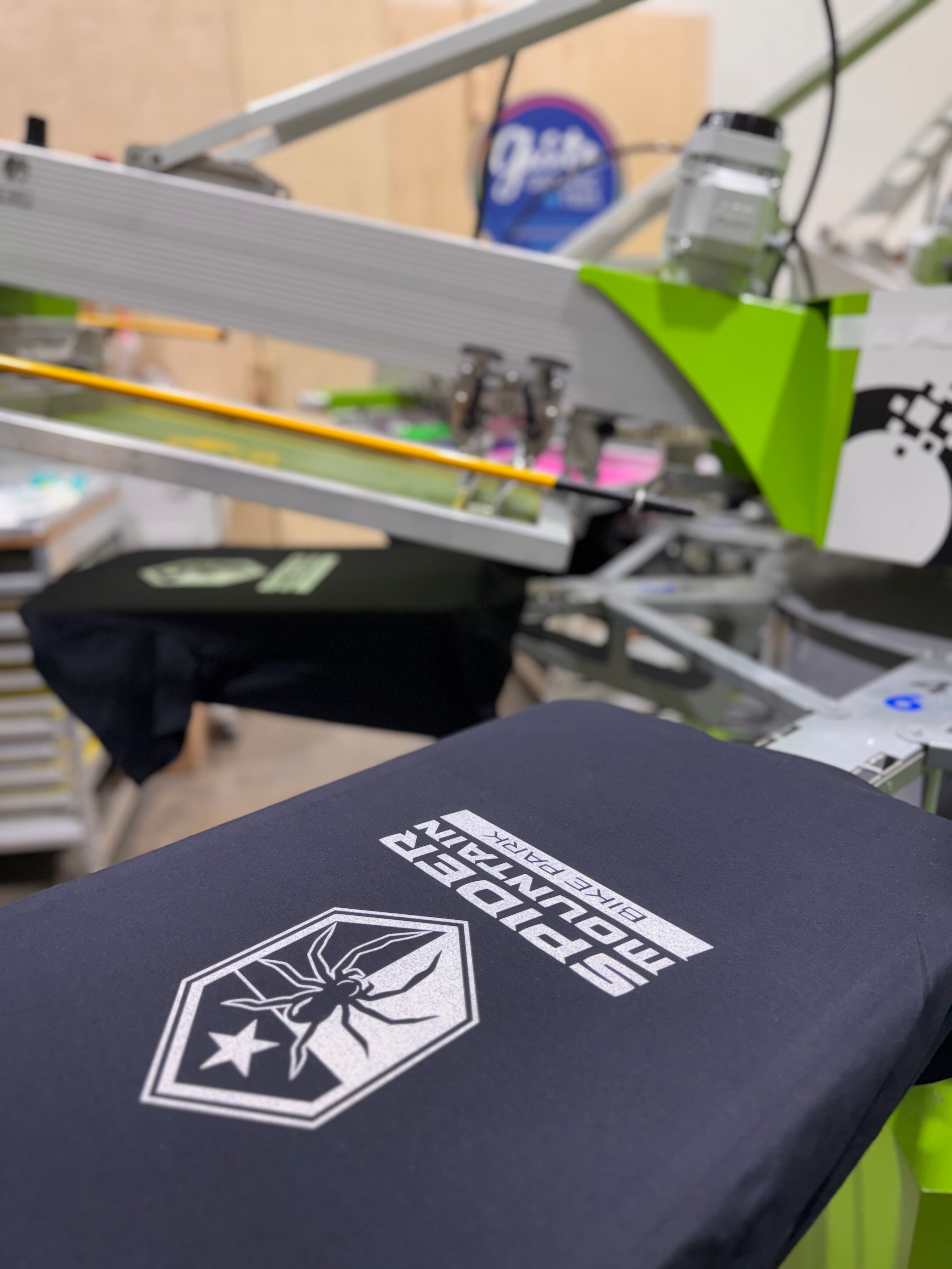 Black t-shirt with a logo on a printing machine