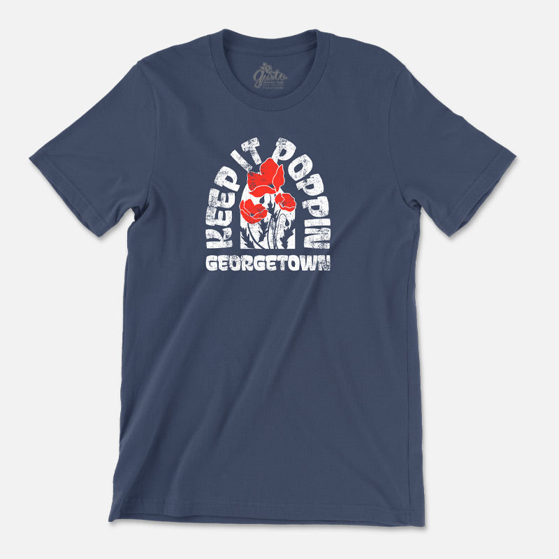 A navy-colored t-shirt with the text 'Keep It Poppin GEORGETOWN, Texas printed on the front. Red poppy flowers