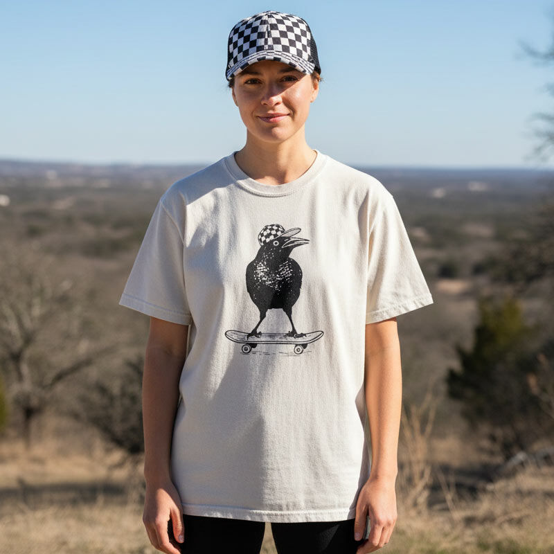 Person wearing a white t-shirt with a black graphic design outdoors