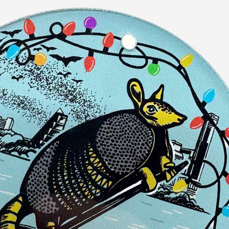 Illustration of an armadillo with Christmas lights and a cityscape background